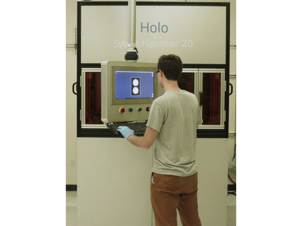 An operator interacts with one of Holo's metal 3D printers.